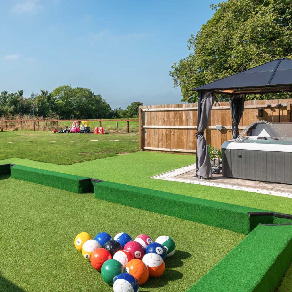 A garden featuring a football pool table and a wooden children's play set.