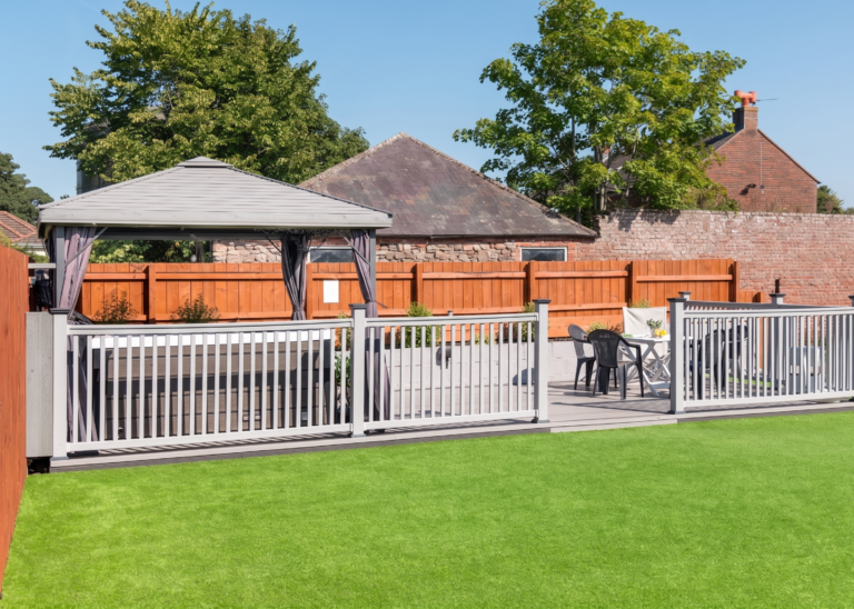 Garden sun deck with a hot tub gazebo and white dining table.